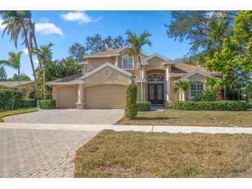 Stunning two-story home with a manicured lawn, mature trees, and a spacious three-car garage at 1370 Pinellas Rd, Belleair, FL 33756