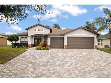 Charming home with three-car garage and decorative stone accents and brick paver driveway at 1604 Harvest Grove Ct, Valrico, FL 33596