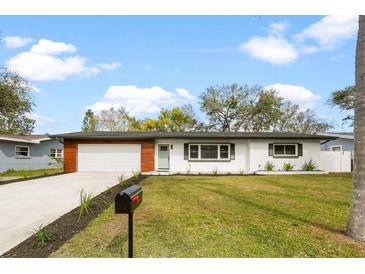 Charming single-story home featuring a well-manicured lawn and a freshly painted exterior at 1624 Barry Rd, Clearwater, FL 33756