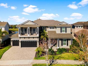 Stately two-story home showcasing meticulous landscaping, a three-car garage, and an inviting balcony at 6326 Brevada Ln, Apollo Beach, FL 33572