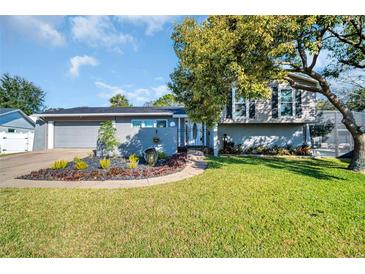 Charming home with a manicured lawn, unique landscaping, and a screened-in pool area at 7115 Edenwood Pl, Tampa, FL 33615