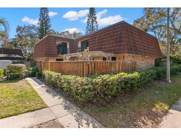 Charming townhome featuring a fenced front yard and a cozy pergola, perfect for outdoor relaxation and privacy at 712 1St Ct, Palm Harbor, FL 34684