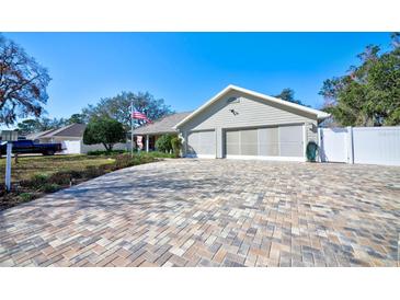Charming single-story home features a brick-paved driveway and a spacious two-car garage with a neutral color palette at 13255 Don Loop, Spring Hill, FL 34609