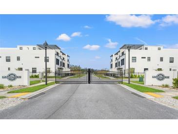 A community entry gate with a contemporary design, flanked by manicured lawns, provides a secure entrance at 6213 64Th N Way, Pinellas Park, FL 33781