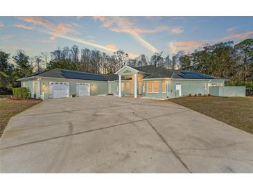 Spacious ranch-style house boasting a large driveway, solar panels, and a charming front entrance at 9911 Mendel Dr, New Port Richey, FL 34654
