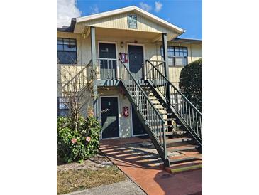 Exterior front view of a two-story building with black stairs, doors, and window trim at 12413 Oak Cedar Pl # 201, Tampa, FL 33612