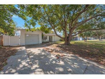Charming single-story home featuring a spacious front yard and a private driveway with an attached garage at 1937 Palm Dr, Clearwater, FL 33763