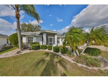 Charming single-story home with mature landscaping and a well-maintained lawn at 2449 E Del Webb Blvd, Sun City Center, FL 33573
