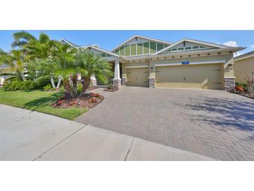 Charming home featuring a three-car garage and a beautifully paved driveway and landscaped front yard at 7328 Paradiso Dr, Apollo Beach, FL 33572