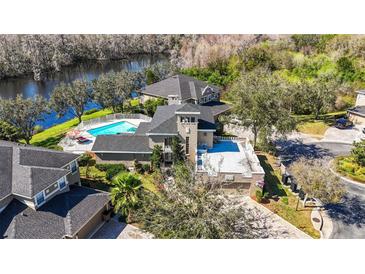 Stunning aerial view of waterfront home with pool and roof deck at 7425 Terrace River Dr, Temple Terrace, FL 33637