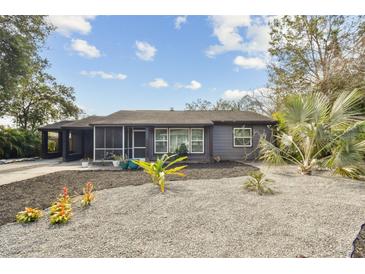 Charming single-story home with modern landscaping, featuring decorative stone and various plants at 1013 E North St, Tampa, FL 33604