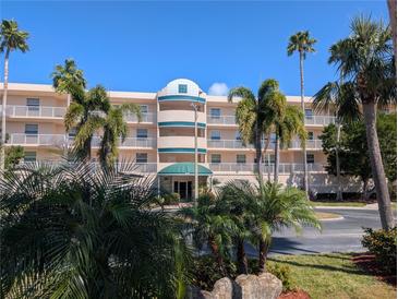 Stunning exterior view of a condo building with lush palm trees and landscaping at 6315 Shoreline Dr # 3305, Madeira Beach, FL 33708