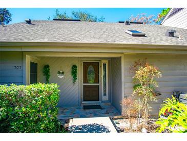 Inviting front entrance with decorative door, stone walkway, and well-maintained landscaping at 707 Old Mill Pond Rd, Palm Harbor, FL 34683
