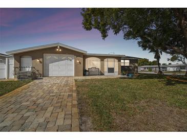 Charming home featuring a paved driveway, well-maintained lawn and mature tree providing nice curb appeal at 9201 Lunar Ln, Port Richey, FL 34668