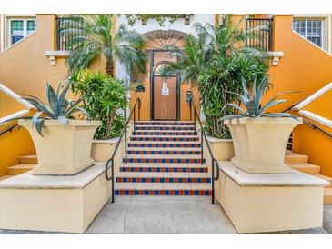 Inviting building entrance with tiled stairs, lush plants and a secure wooden door, creating a welcoming atmosphere at 100 4Th S Ave # 202, St Petersburg, FL 33701