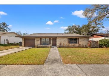 Charming single-story home featuring a stone facade, well-maintained lawn, and a cozy front porch with bench at 1314 Oak Valley Dr, Seffner, FL 33584