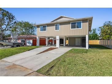 Stunning elevated home features a two-car drive, lush lawn, and modern neutral paint at 227 84Th Ne Ave, St Petersburg, FL 33702