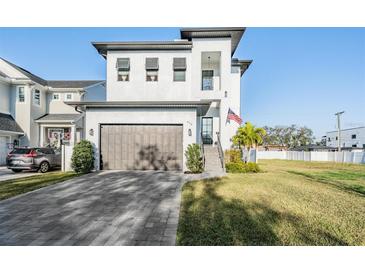 Two story home with a large garage and a neatly kept lawn and an American flag hanging at 619 Danube Ave, Tampa, FL 33606