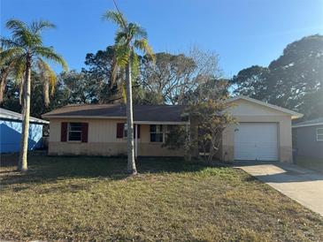 Charming single Gathering home featuring brick accents, a garage and well manicured lawn and tropical landscaping at 6347 S Lansdale Cir, Tampa, FL 33616