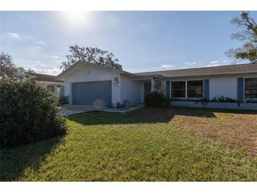 Charming single-story home featuring a well-maintained lawn and attached garage at 1091 Mcfarland St, Dunedin, FL 34698