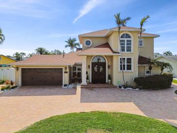 Stately two-story home featuring a large driveway, attached garage, and mature palm trees at 1336 51St Ne Ave, St Petersburg, FL 33703