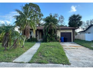 Charming single-story home featuring a cozy front yard with mature trees and a private driveway at 1804 Bayou Grande Ne Blvd, St Petersburg, FL 33703