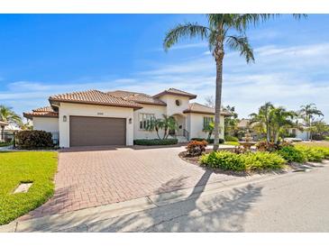 Stunning Mediterranean style home featuring a paver driveway, lush landscaping, and a two-car garage at 2028 Illinois Ne Ave, St Petersburg, FL 33703