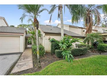 Charming home with a well-maintained front yard and tropical landscaping featuring mature palm trees at 4307 Woodmans Chart # 132, Sarasota, FL 34235