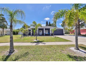 Charming single-story home with well-manicured lawn, lush landscaping, and an inviting two-car garage at 7609 Clair Wood Ct, Apollo Beach, FL 33572