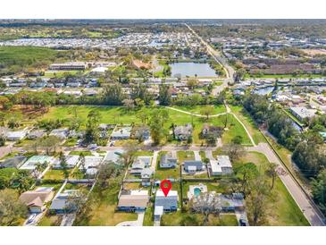 An aerial view showing the neighborhood, nearby pond, and the home's location in relation to the surrounding area at 130 81St Ne Ave, St Petersburg, FL 33701