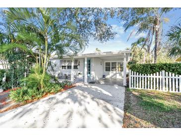 Charming single-story home with a well-manicured lawn, white picket fence, and covered front parking at 349 Shirley Ave, Belleair, FL 33756