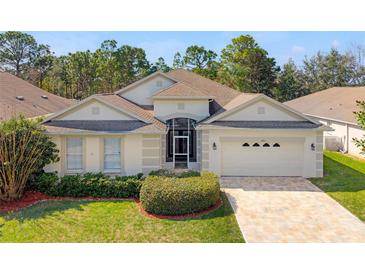 Charming single-story home with a well-manicured lawn, complemented by lush landscaping and a welcoming two-car garage at 4421 Larkenheath Dr, Spring Hill, FL 34609