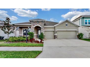 Beautiful home featuring a three-car garage and stone accents on the facade at 5317 Del Coronado Dr, Apollo Beach, FL 33572