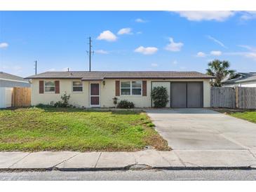 Charming single-story home with a well-maintained front yard and attached two-car garage and a light-colored exterior at 6906 Sandalwood Dr, Port Richey, FL 34668