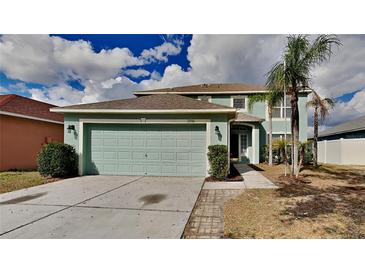 Two-story home featuring an attached two-car garage, and a well manicured lawn at 13506 Copper Head Dr, Riverview, FL 33569