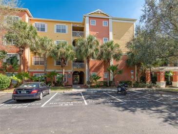 Condo exterior showing colorful facade, palm trees, parking, and secured entrance in a well-maintained community at 4207 S Dale Mabry Hwy # 6207, Tampa, FL 33611