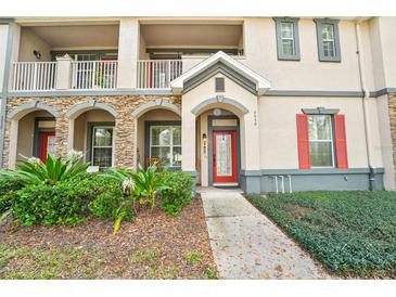 Inviting condo exterior featuring a red front door and charming stone accents at 6040 Fishhawk Crossing Blvd # 6040, Lithia, FL 33547