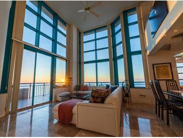 Light-filled living room featuring walls of windows, tile flooring, and a comfortable seating area at 1520 Gulf Blvd # Ph1 1901, Clearwater Beach, FL 33767