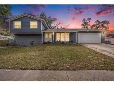 Charming two-story home featuring a well-maintained lawn and inviting facade against a colorful twilight sky at 8019 Capwood Ave, Temple Terrace, FL 33637