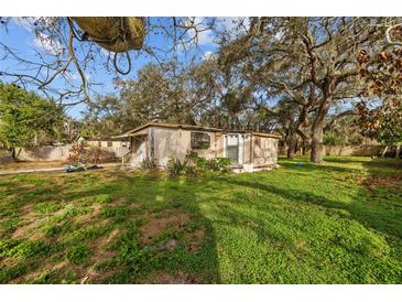 Charming single-story home featuring mature trees and a spacious front yard at 9435 Ottawa St, New Port Richey, FL 34654