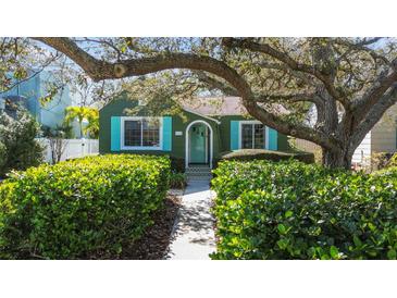 Charming green home with lush landscaping, teal shutters, and inviting walkway at 114 27Th N Ave, St Petersburg, FL 33704