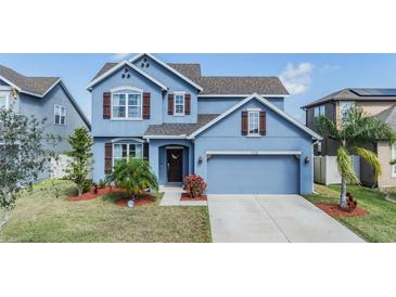 Charming two-story blue home with a well-maintained yard and two-car garage at 11938 Bahia Valley Dr, Riverview, FL 33579