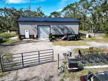 Spacious garage with roll up door, metal roof, and plenty of yard space at 13215 Seminole Trl, Wimauma, FL 33598