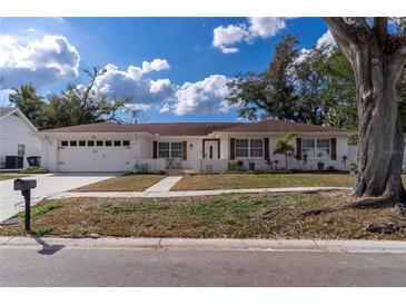 Charming single-story home featuring a white brick facade, attached garage, and well-maintained front yard at 13508 Greenleaf Dr, Tampa, FL 33613