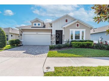 Beautiful single Gathering home with a well manicured lawn and a brick paver driveway at 14005 Kingfisher Glen Dr, Lithia, FL 33547