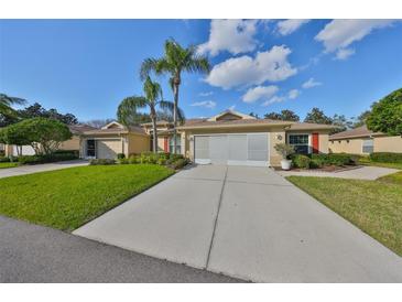 Charming home with well-maintained lawn, long driveway, red shutters, and lovely landscaping at 1912 Acadia Greens Dr, Sun City Center, FL 33573