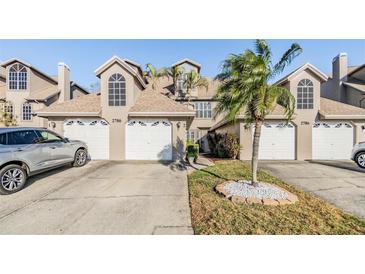 Inviting exterior view of townhomes featuring well-manicured lawns and driveways with ample parking space at 2786 Countryside Blvd # 2, Clearwater, FL 33761