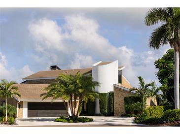 Stunning home featuring unique architectural design, lush landscaping, and a circular driveway, creating an inviting curb appeal at 4900 59Th S Ave, St Petersburg, FL 33715