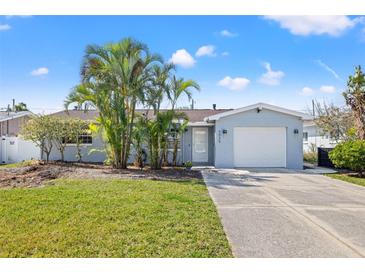 Charming single Gathering home with a manicured lawn, mature palm trees, and attached one car garage at 5926 Bayou Grande Ne Blvd, St Petersburg, FL 33703