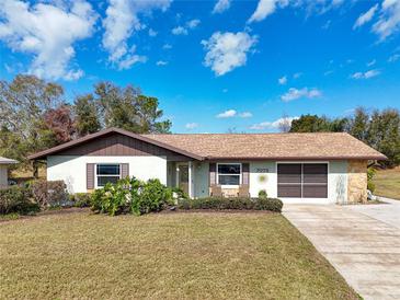 Charming single-story home with a well-manicured lawn and an attached two-car garage at 7078 Lexington Cir, Brooksville, FL 34602